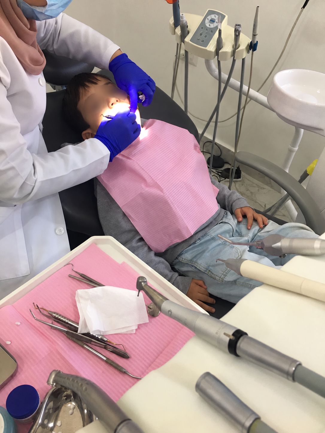 رعاية أسنان طفل في العيادة مع تغبيش منطقة العينين